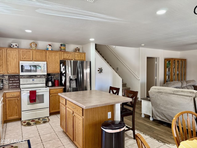 1758 E San Xavier Dr, Casa Grande, AZ 85122 - kitchen with white appliances, a kitchen bar, a kitchen island, open floor plan, and recessed lighting