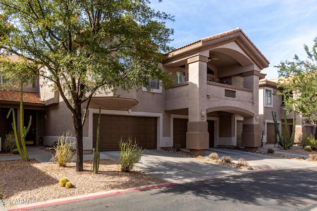 mediterranean / spanish-style house featuring an attached garage, a tile roof, concrete driveway, and stucco siding