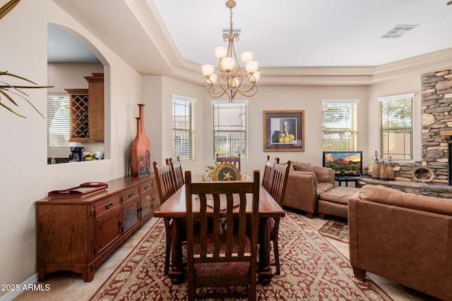 dining space featuring a notable chandelier and a raised ceiling