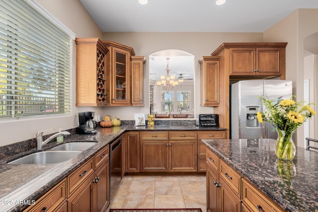 kitchen featuring stainless steel refrigerator with ice dispenser, black dishwasher, sink, and a wealth of natural light