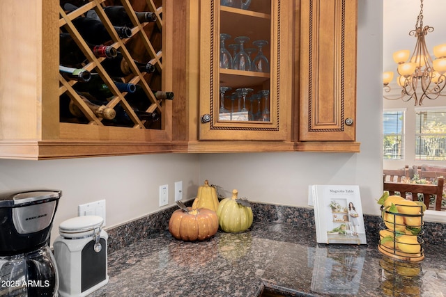 interior details featuring pendant lighting, dark stone counters, and a notable chandelier