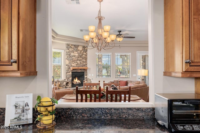 dining room with plenty of natural light, an inviting chandelier, and a fireplace