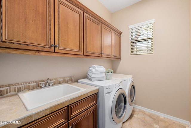 clothes washing area featuring cabinets, separate washer and dryer, and sink