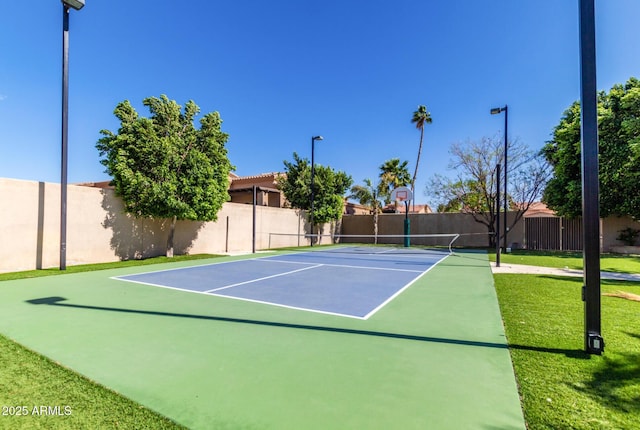 view of sport court with a lawn