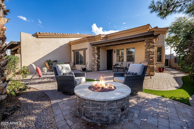 rear view of house featuring a patio and an outdoor living space with a fire pit