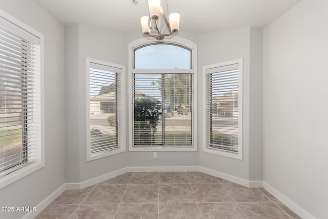 unfurnished dining area with an inviting chandelier and light tile patterned floors