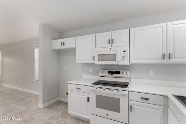 kitchen featuring light tile patterned floors, white cabinets, and white appliances