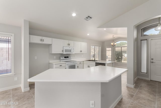 kitchen featuring sink, white cabinets, a chandelier, a center island, and white appliances