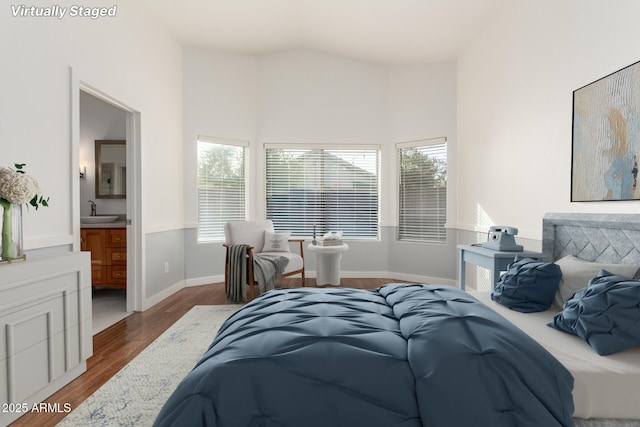 bedroom featuring ensuite bath, wood-type flooring, and sink