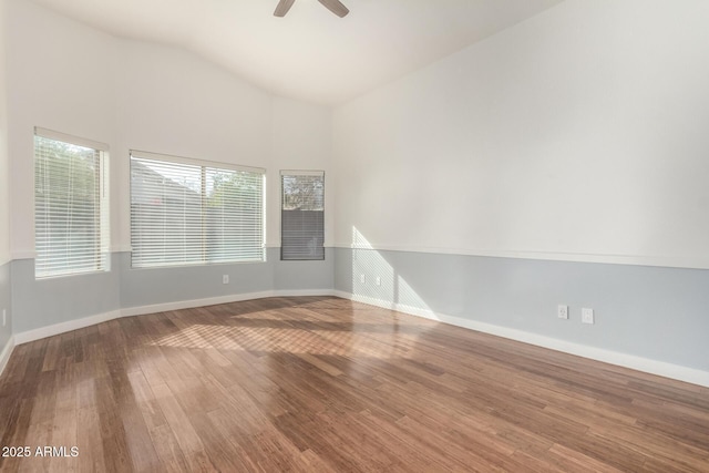 spare room featuring wood-type flooring, high vaulted ceiling, and ceiling fan