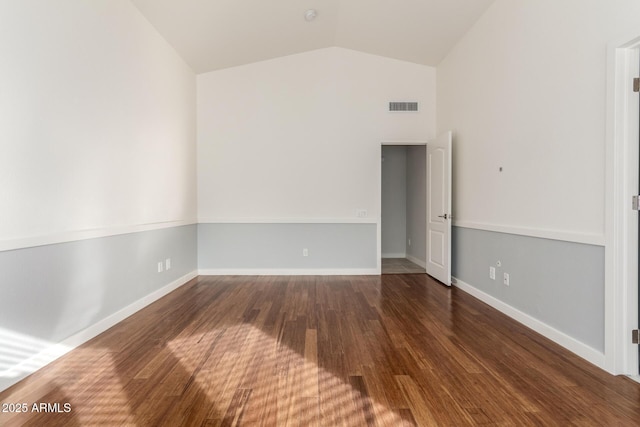 unfurnished room featuring vaulted ceiling and dark wood-type flooring