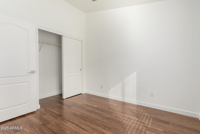 unfurnished bedroom featuring dark wood-type flooring and a closet