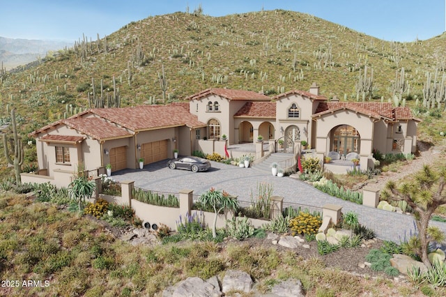 3284 W Highlands Dr, Buckeye, AZ 85396 - mediterranean / spanish-style house with a garage, stucco siding, a fenced front yard, driveway, and a mountain view
