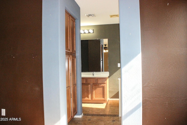 corridor with light tile patterned flooring and sink