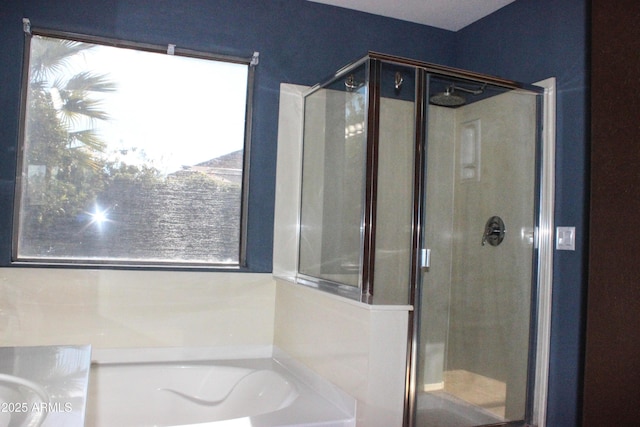 bathroom featuring shower with separate bathtub