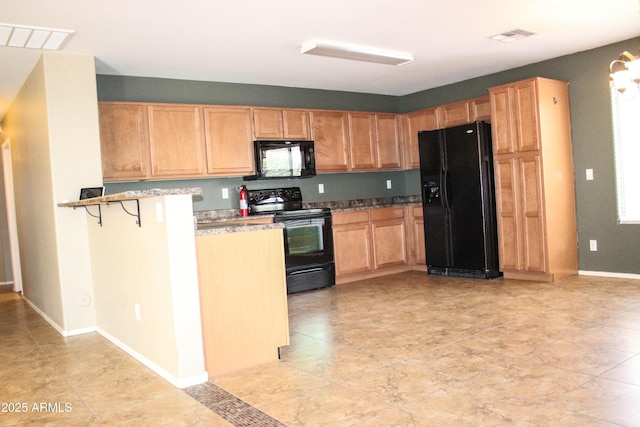 kitchen featuring kitchen peninsula, a breakfast bar area, and black appliances