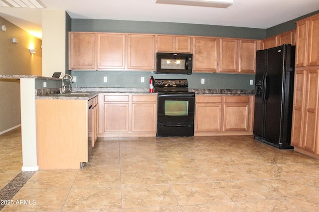 kitchen featuring dark stone countertops, kitchen peninsula, sink, and black appliances