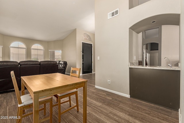 3946 N 112th Ave, Avondale, AZ 85392 - dining room featuring arched walkways, dark wood-style flooring, and baseboards