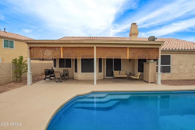 3946 N 112th Ave, Avondale, AZ 85392 - back of house with a chimney, an outdoor pool, a patio, stucco siding, and a tiled roof
