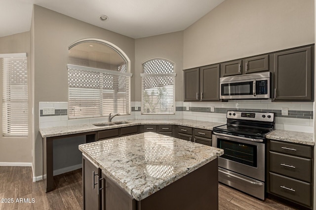 3946 N 112th Ave, Avondale, AZ 85392 - kitchen with stainless steel appliances, a sink, a center island, backsplash, and vaulted ceiling