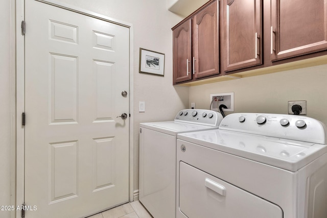 clothes washing area featuring cabinets, light tile patterned floors, and separate washer and dryer