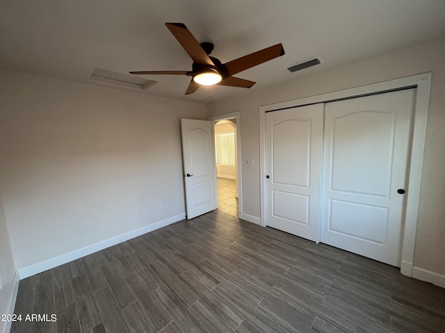 unfurnished bedroom with ceiling fan, dark hardwood / wood-style flooring, and a closet