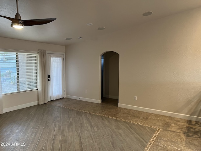 empty room with ceiling fan and dark hardwood / wood-style flooring