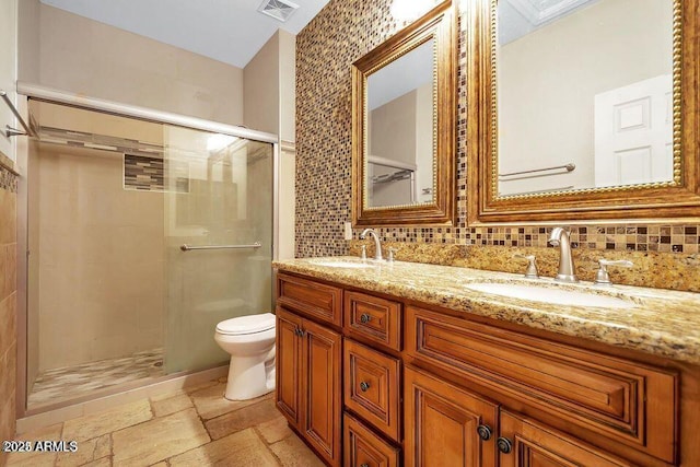 bathroom with tasteful backsplash, vanity, toilet, and walk in shower