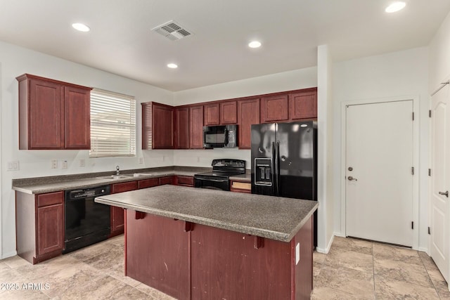 kitchen featuring a kitchen breakfast bar, a center island, sink, and black appliances