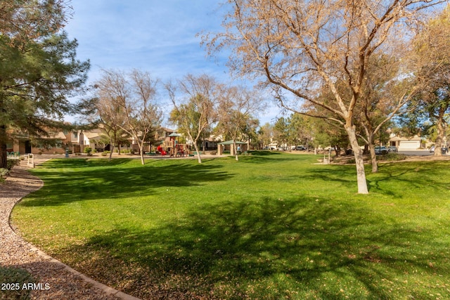 view of home's community with a playground and a lawn