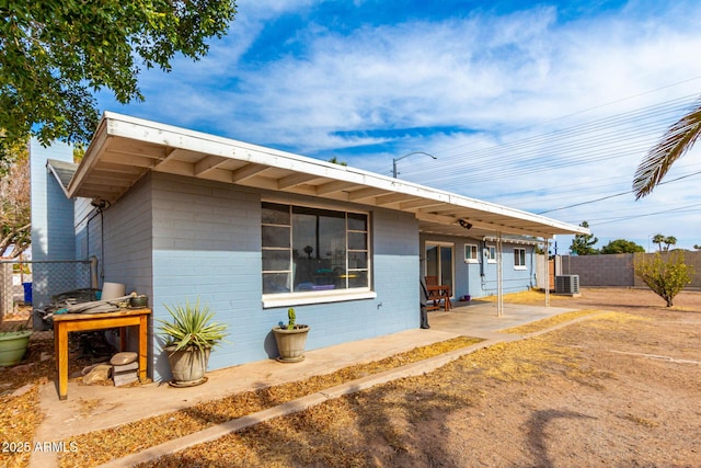 single story home with cooling unit and a patio area