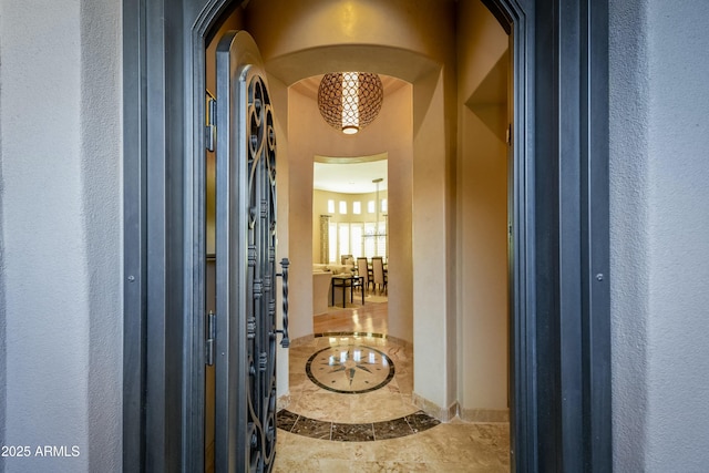 foyer entrance featuring arched walkways and a textured wall