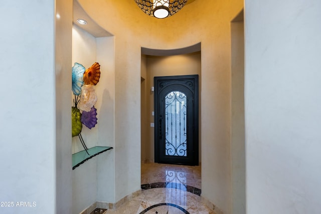 foyer with marble finish floor and baseboards