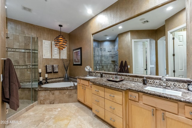 bathroom featuring a bath, a stall shower, a sink, and visible vents