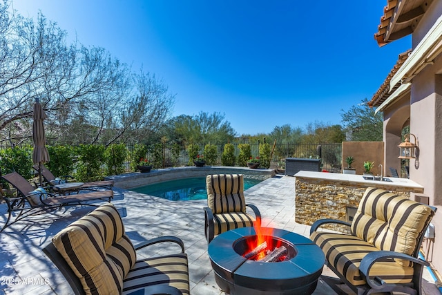 pool featuring a fenced backyard, a patio, a fire pit, and a jacuzzi