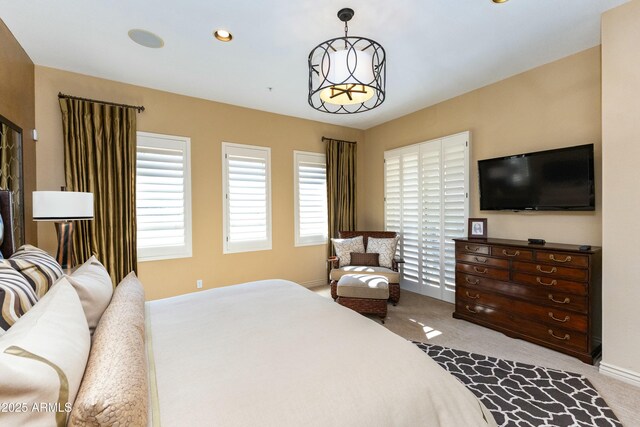 bedroom featuring light carpet, a chandelier, and baseboards