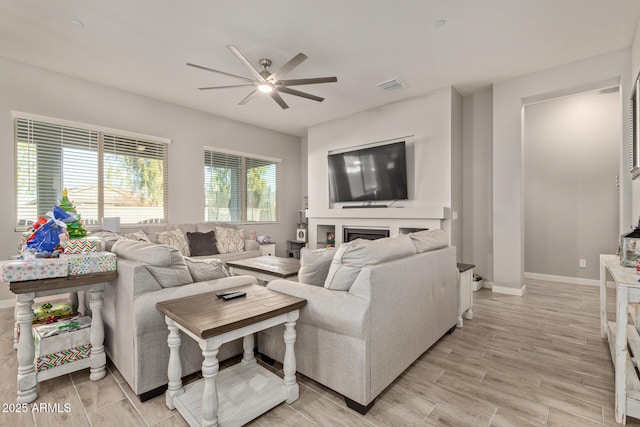 living room with a fireplace and ceiling fan