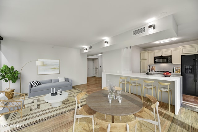 living room with light wood-type flooring and sink