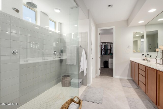 full bath featuring vanity, visible vents, baseboards, tile patterned floors, and walk in shower