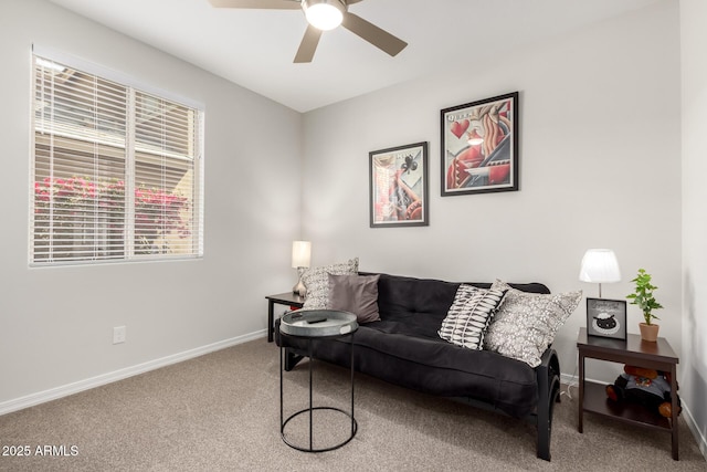 carpeted living area featuring baseboards and a ceiling fan