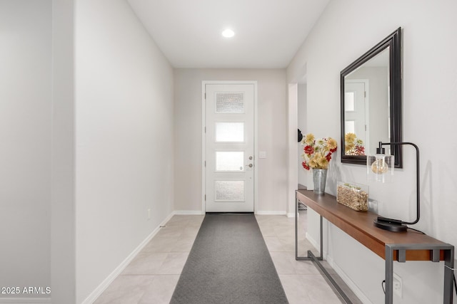 doorway to outside featuring light tile patterned floors and baseboards