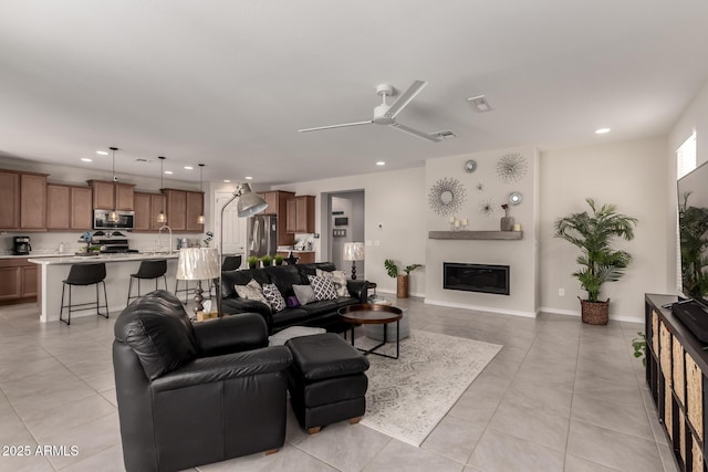 living area with ceiling fan, recessed lighting, visible vents, baseboards, and a glass covered fireplace