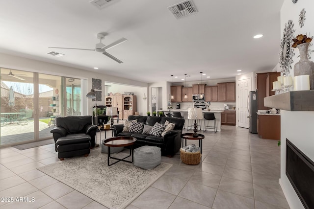 living area featuring ceiling fan, light tile patterned flooring, visible vents, and recessed lighting