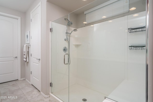 bathroom with a shower with shower door and tile patterned floors