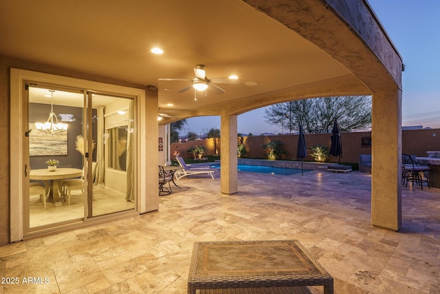 patio terrace at dusk featuring ceiling fan and a fenced in pool