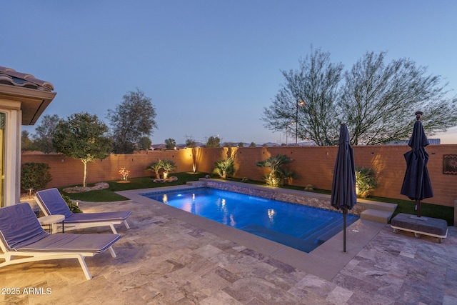 pool at dusk with a patio