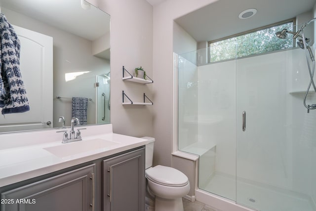 bathroom featuring vanity, toilet, and a shower with door