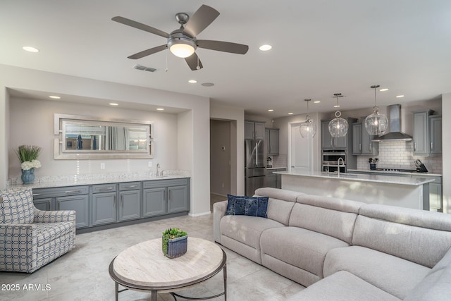 living room with wet bar and ceiling fan