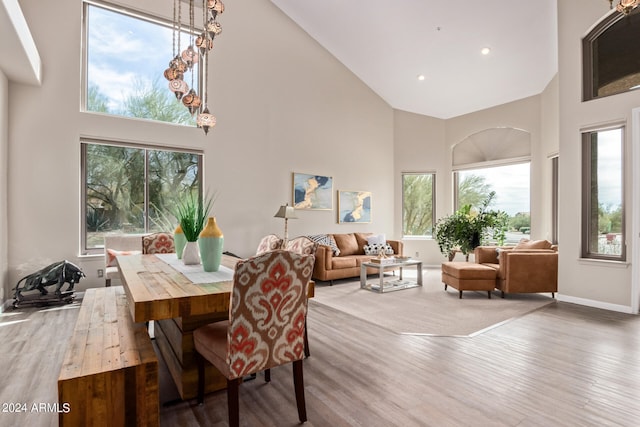 dining area featuring a wealth of natural light, high vaulted ceiling, and wood-type flooring