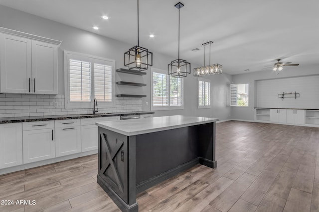 kitchen with a kitchen island, a wealth of natural light, hanging light fixtures, and sink